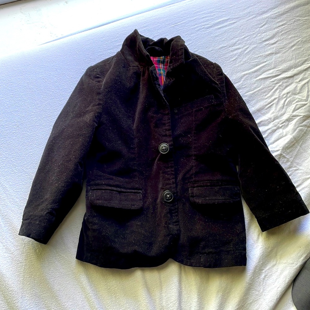 A black blazer for toddlers, has a flannel style in the inside.